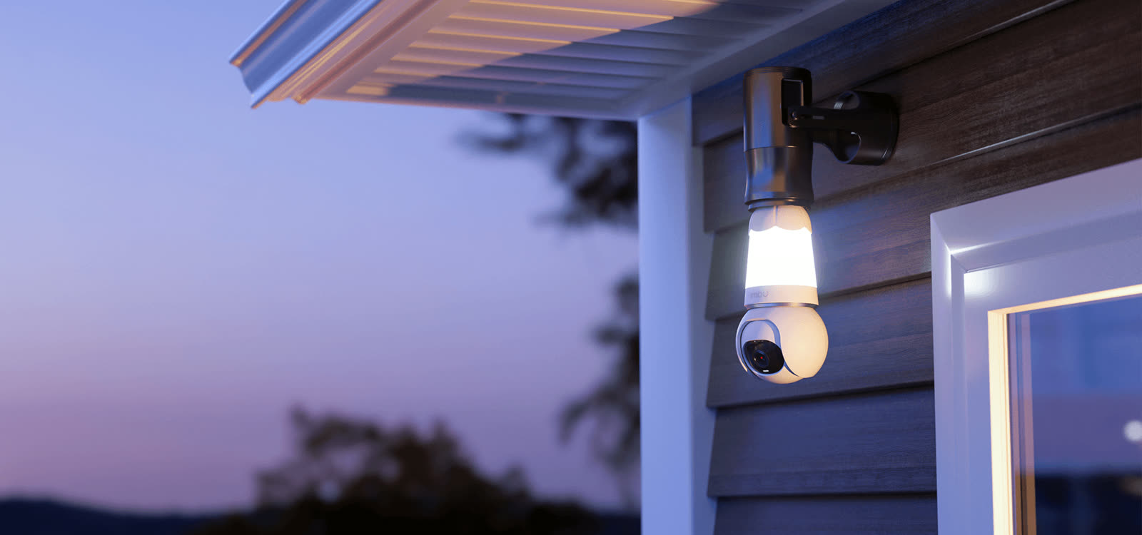 IMOU bulb camera glowing on an outdoor wall at night