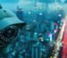 Close-up of a CCTV camera with infrared LEDs overlooking a blurry, glowing city skyline and busy highway at night.